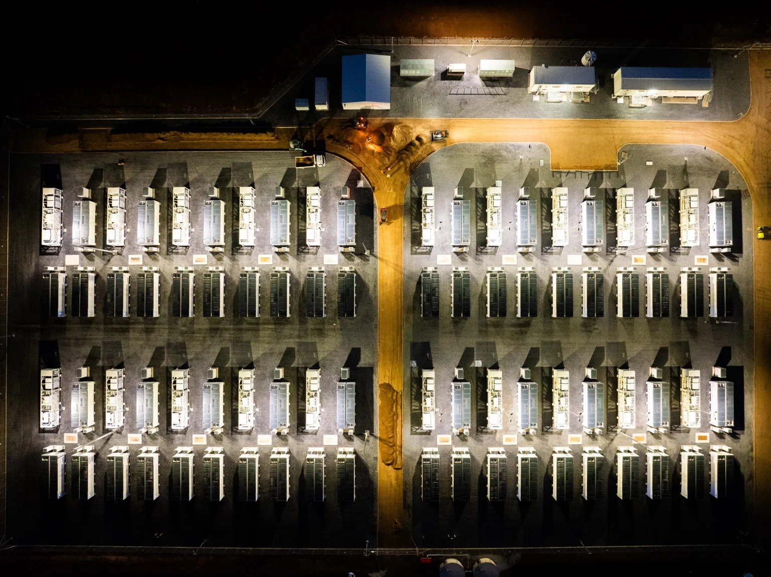 Aerial view of a large battery energy storage system site at night.